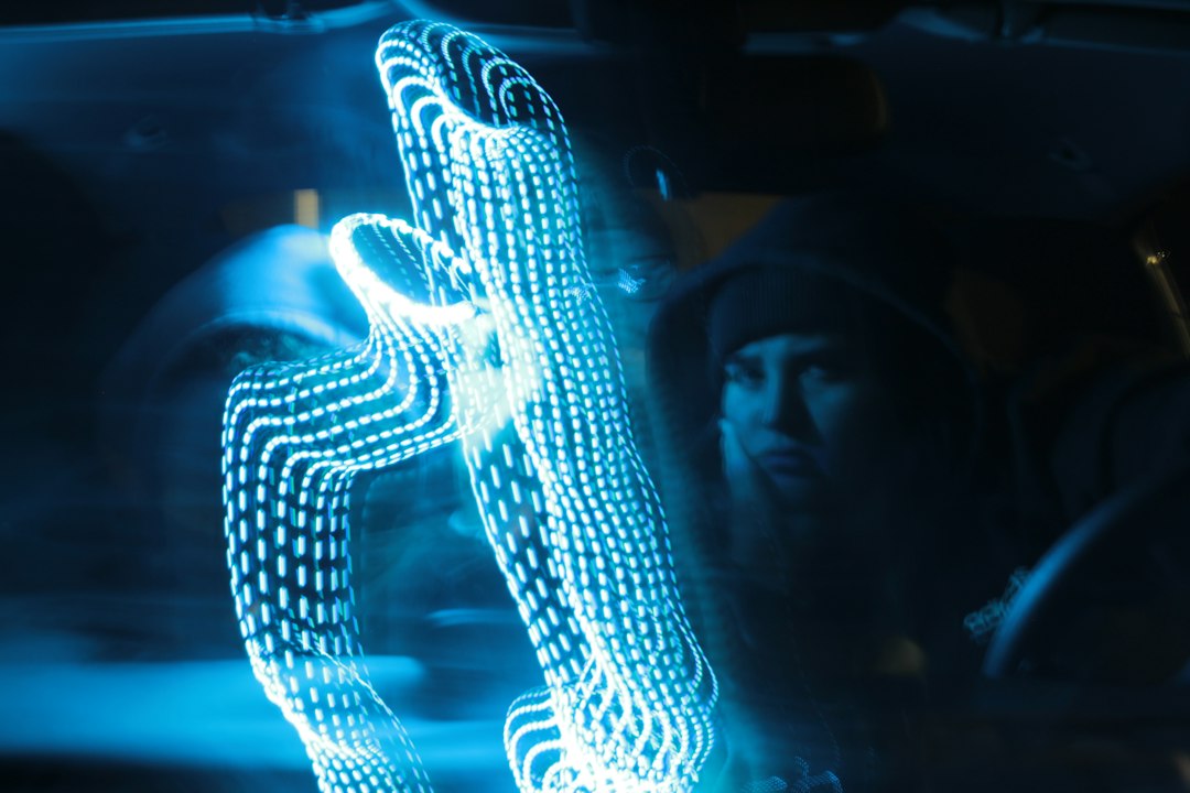 Professional's hands interacting with a futuristic, glowing data interface, symbolizing human collaboration with artificia...